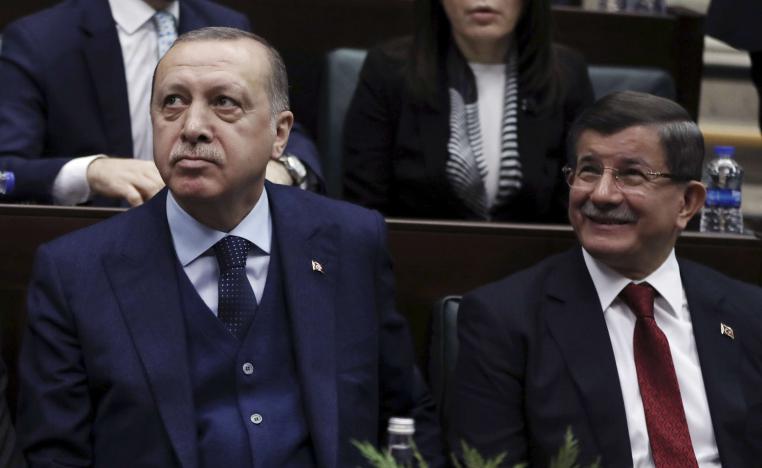 أحمد داوود أوغلو (يمين) يجلس إلى جانب أردوغان