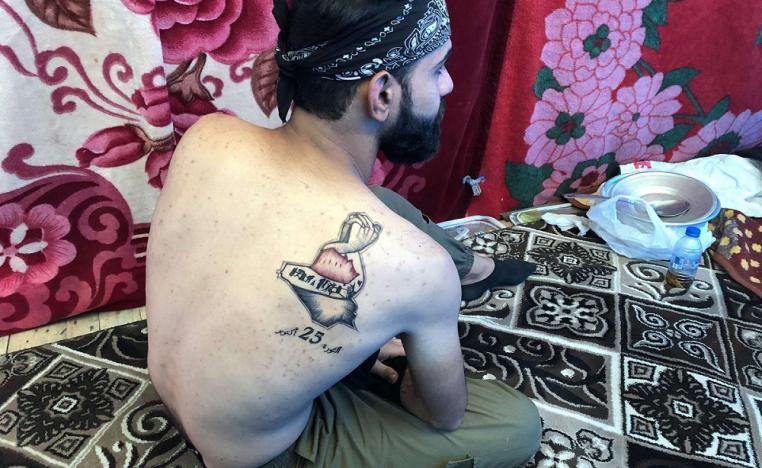 وشم الثورة يظهر على كتف أحد الشباب العراقيين
