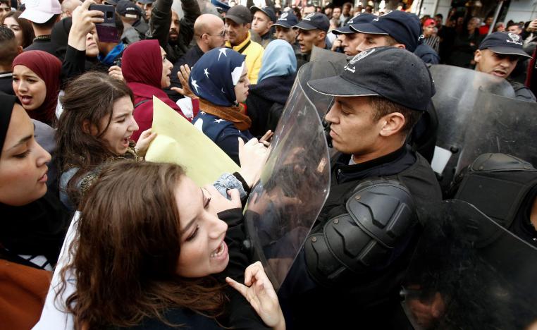 Police officers try to disperse demonstrators during a protest rejecting upcoming presidential election in Algiers