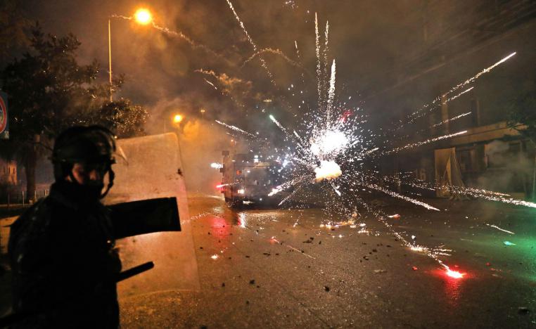 Supporters of Lebanon's Shiite Hezbollah and Amal groups hurl fireworks at security forces in Beirut