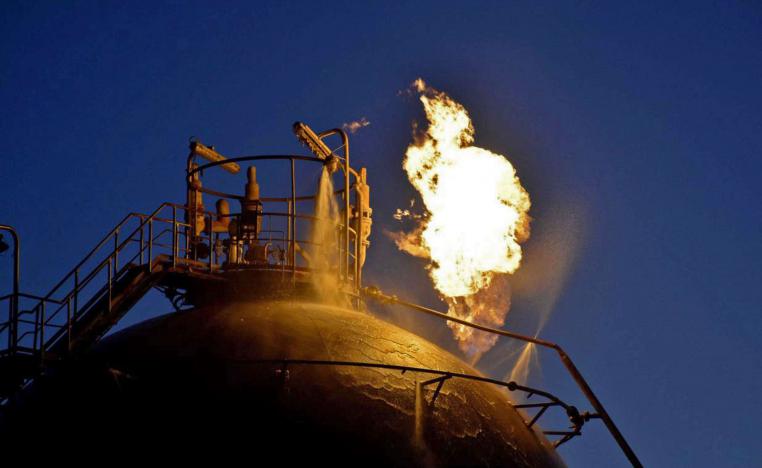 Flame erupting from an oil tank following an attack on Syria's Homs Refinery