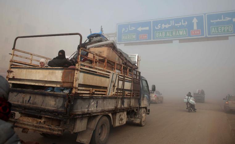 Syrians carrying their belongings drive towards the northern areas of Syria's Idlib province