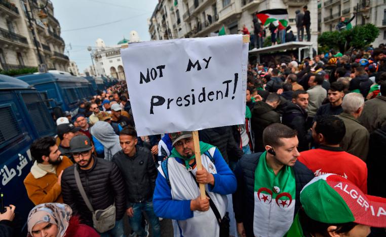 An Algerian protester lifts a placard in the capital Algiers