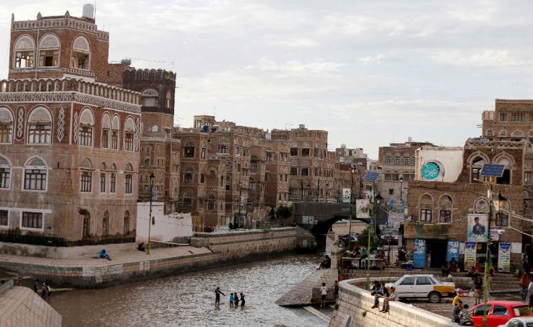 Boys play on a floodway following heavy rains in the old quarter of Sanaa