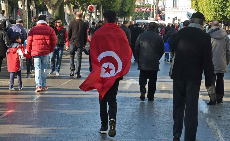 متظاهر تونسي يشارك الاحتفال بذكرى الثورة
