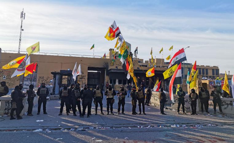 Protesters and militia fighters gather outside the US embassy in Baghdad