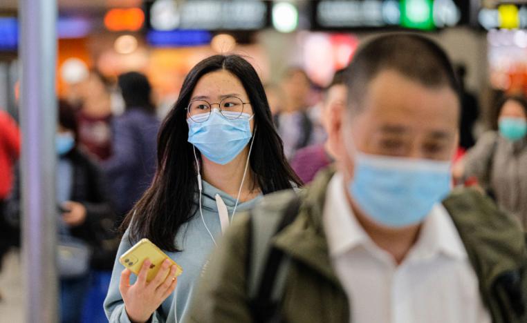 Travellers wear surgical mask at the departure hall of the West Kowloon Rail station in Hong Kong