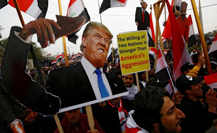 Supporters of Iraqi Shi'ite cleric Moqtada al-Sadr carry placards depicting US President Donald Trump