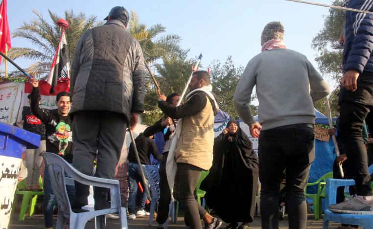Iraqi anti-government protesters celebrate outside their protest tents in Baghdad's Tahrir Square following news of the killing of Qassem Soleimani