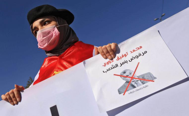 طالبة عراقية ترفع لافتة في كربلاء ترفض تكليف محمد علاوي برئاسة الحكومة