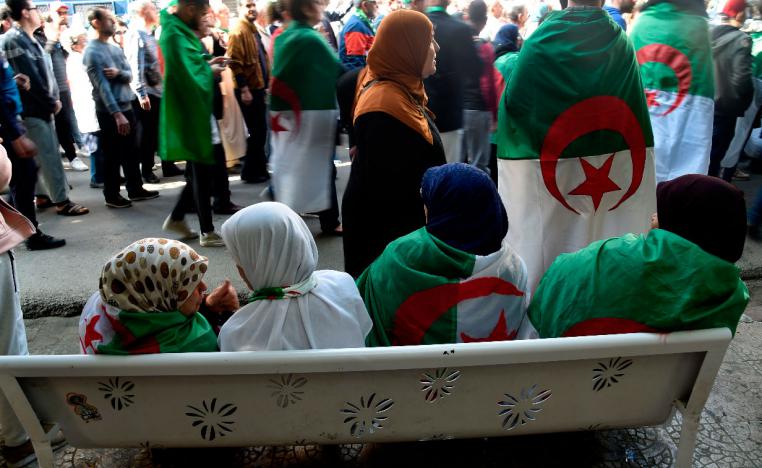 Algerians, clad in national flags, march in an anti-government demonstration in the capital Algiers