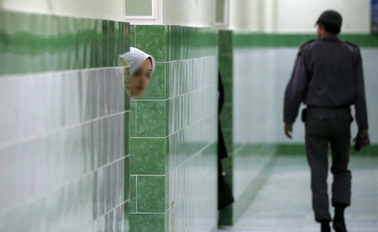 An Iranian inmate peers from behind a wall at the infamous Evin prison north of Tehran