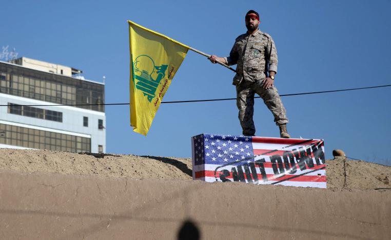 An Iranian guard holds a Hezbollah flag