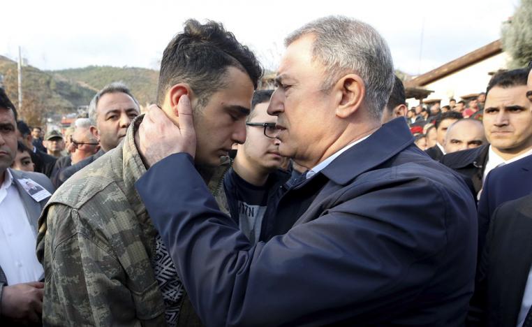 وزير الدفاع التركي خلوصي اكار يتحدث مع احد زملاء الجنود القتلى في سوريا