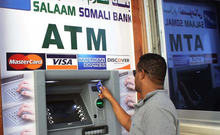 A Somali man uses the first-ever ATM cash withdrawal machine installed in Mogadishu