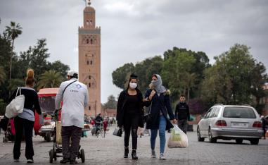 أشخاص يرتدون كمامات واقية يسيرون في ساحة جامع الفنا في مراكش