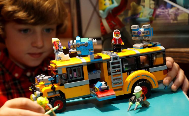 طفل يبني حافلة من قطع الليغو