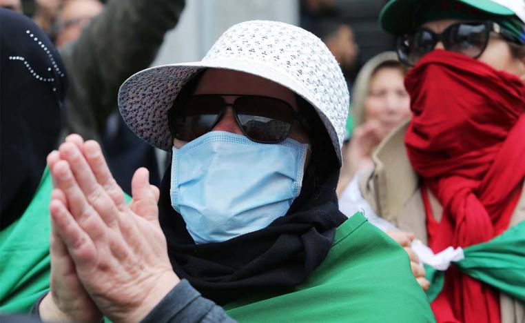 Algerian woman wearing a face mask gestures during an anti-government protest
