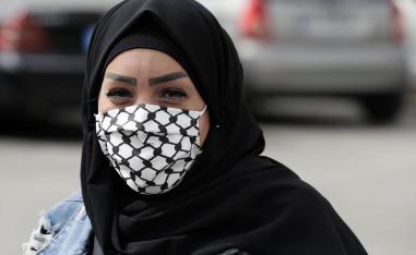 فلسطينية من مخيم برج البراجنة في بيروت ترتدي كمامة على شكل كوفية فلسطينية