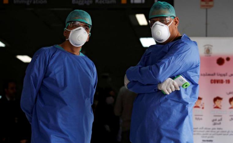 Health officials wait to test passengers as part of security measures to avoid coronavirus in the country, at Damascus international airport