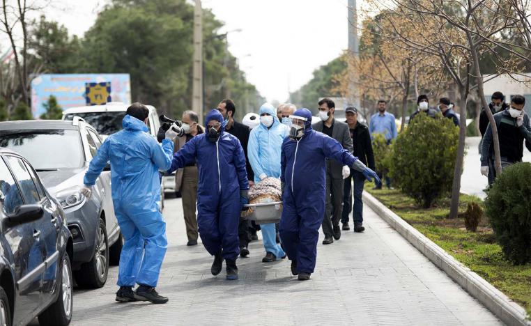 Men wearing protective gear carry the body of Fatemeh Rahbar, a lawmaker-elect from Tehran constituency, who died on Saturday after being infected with the new coronavirus