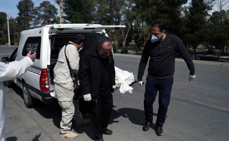 Iranian men carry the coffin of the journalist Abdollah Zavieh, who passed away due to coronavirus disease