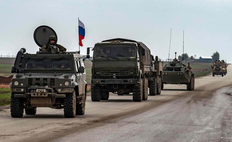 A Russian military convoy is seen in front of a US military convoy on the key M4 highway in Syria's northeastern Hasakeh province