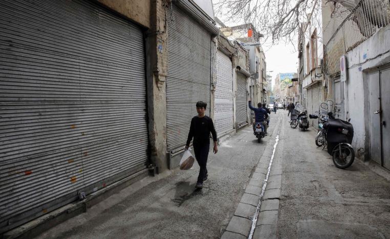 An Iranian youth walks past closed shops in Tehran's grand bazaar