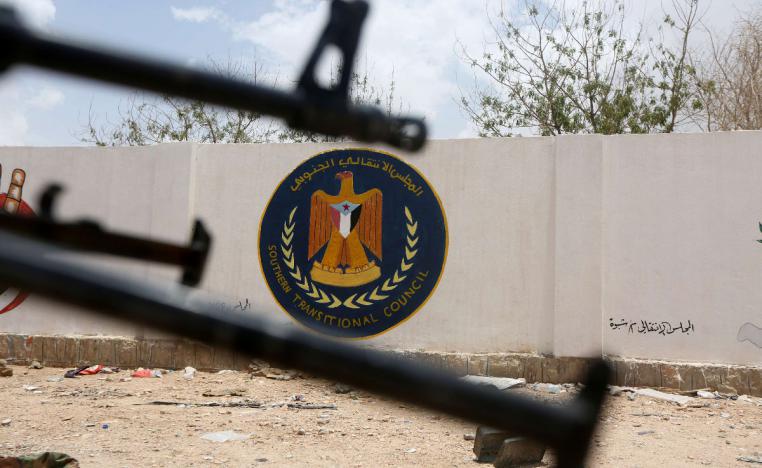 The emblem of the STC is seen between weapons held by Yemeni government soldiers