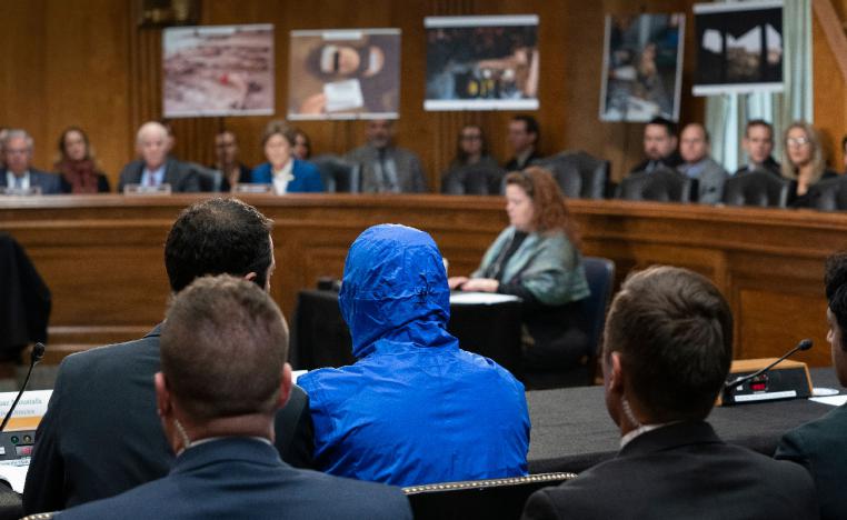 A Syrian military defector using the pseudonym 'Caesar' wears a hood as he testifies before the Senate Foreign Relations Committee