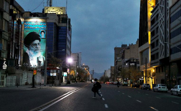 A pedestrian crosses an empty street in Tehran