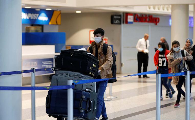 A passenger wearing a protective mask pushes a trolley at Beirut's international airport 