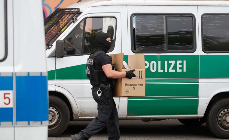 Police carry evIdence in a moving box out of Al-Irschad Mosque during a raid in Berlin