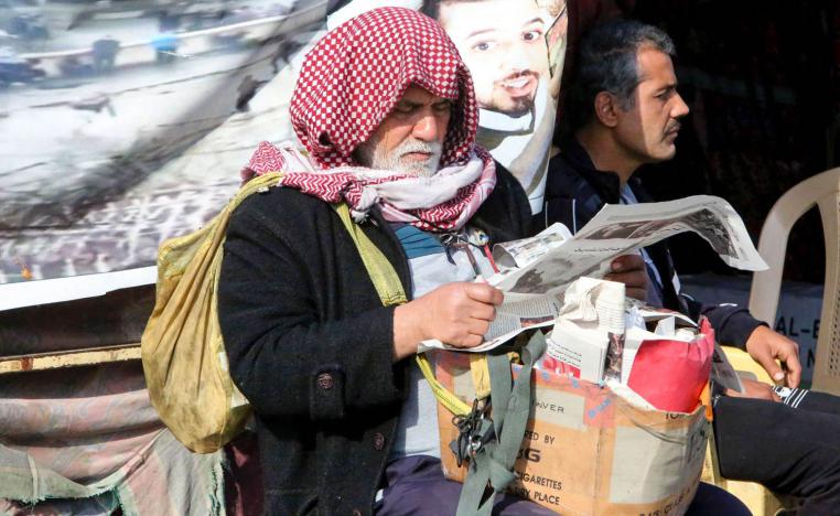 عراقي يتصفح جريدة في ساحة الاحتجاجات وسط بغداد