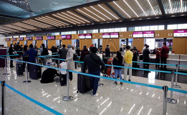 Passengers wearing protective face masks queue for a check-in, during the outbreak of the coronavirus disease (COVID-19), at Istanbul Airport