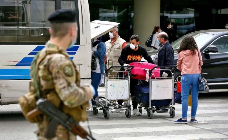 Passengers putting their luggage in a bus upon their arrival at Beirut airport from Saudi Arabia