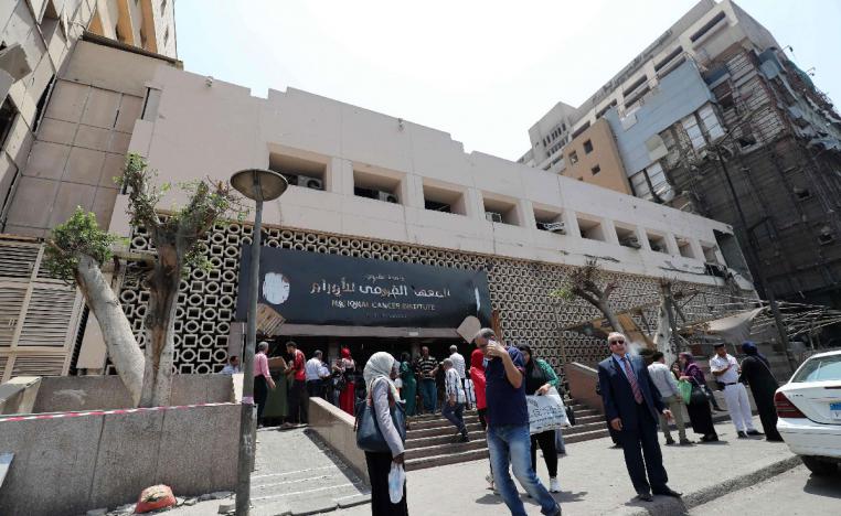 Egyptians walk outside the National Cancer Institute in the capital Cairo