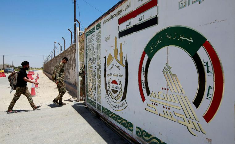 Members of Iraqi Popular Mobilization Forces (PMF) walk as they enter their headquarters in the city of Najaf