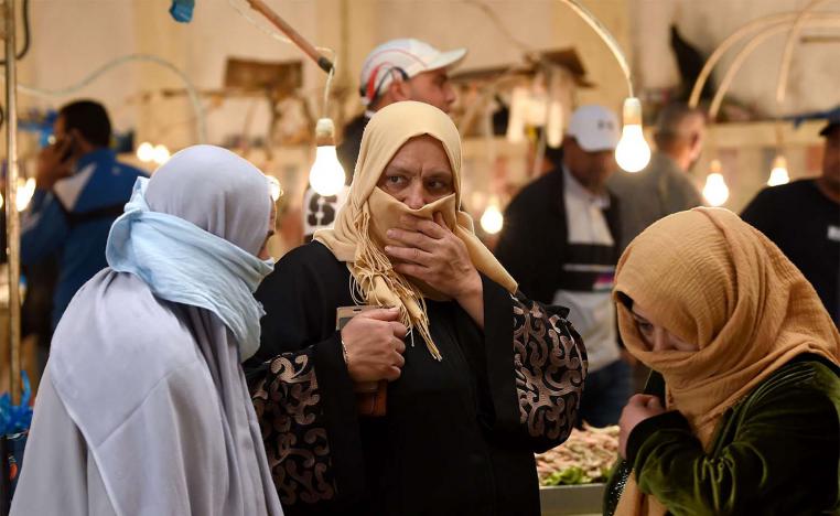 Tunisian women, covering their faces, walk past stalls in a central market in the capital Tunis