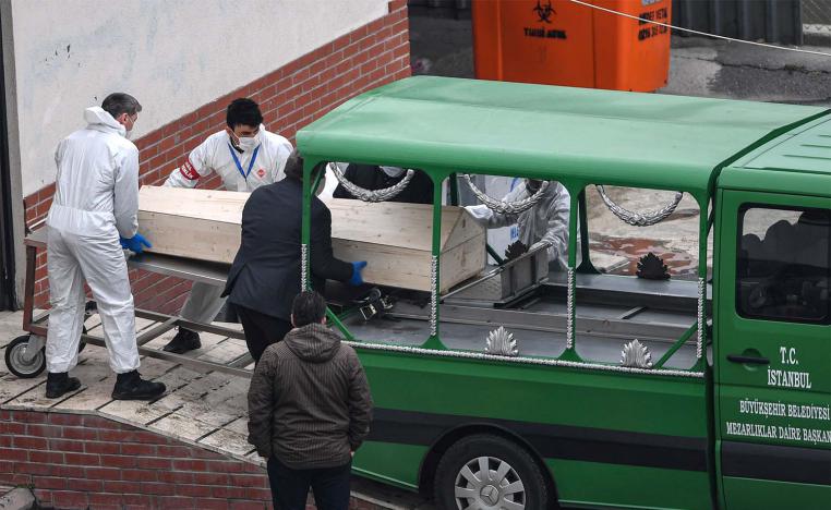 Officials put a coffin inside a funeral vehicle in an Istanbul morgue