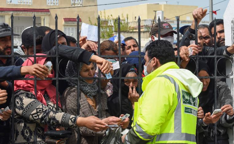 Impoverished Tunisian citizens gather with their identification cards in front of the headquarters of Mnihla delegation, in Ariana Governorate outside Tunis