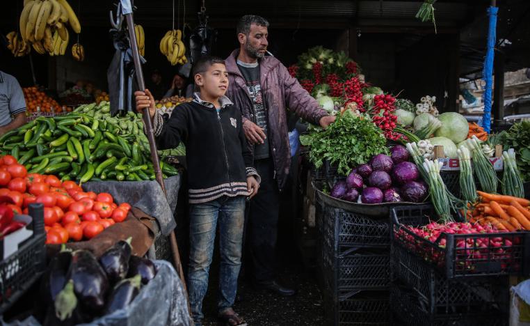 Syrians buy fresh vegetables at a street market
