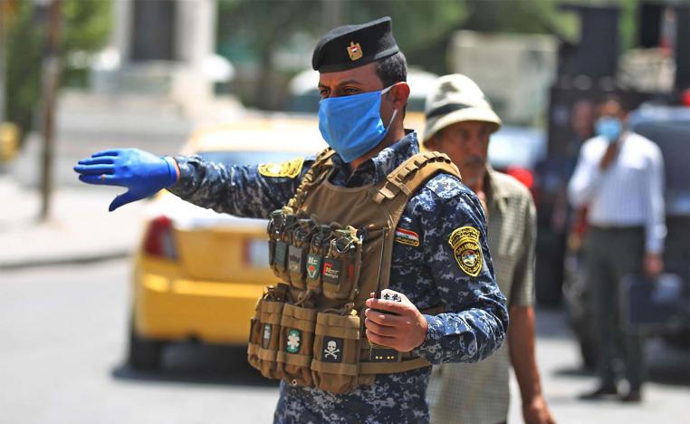 Member of the Iraqi security forces wearing protective masks keep watch at Tahrir Square in central Baghdad
