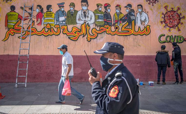  Policeman walks past artists working on a mural thanking essential workers amid the COVID-19 pandemic in Sale