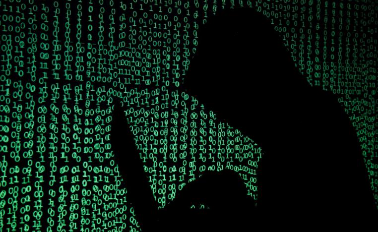  رجل مقنع يحمل جهاز كمبيوتر محمولا لإيضاح عملية قرصنة