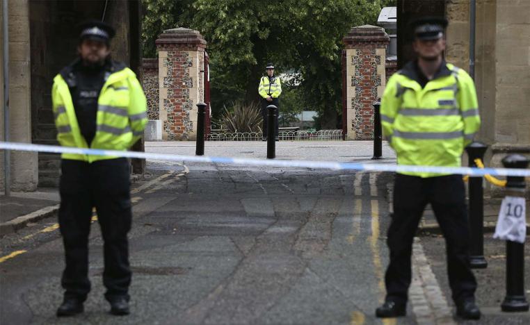 Police stand guard at the Abbey gateway of Forbury Gardens park in Reading town centre following Saturday's stabbing attack in the gardens