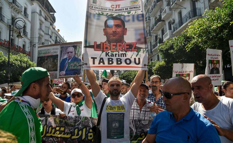 Algerian protester marches with a sign calling to set free politician Karim Tabbou during a protest last September