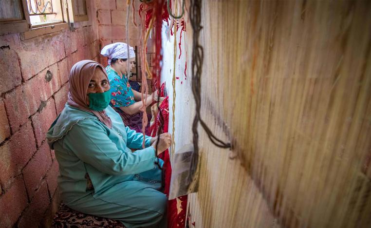 Moroccan rug weavers create a carpet at a workshop in the city of Sale