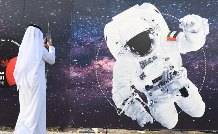 اماراتي يلتقط صورة لرائد فضاء يحمل العلم الوطني الإماراتي خارج مركز محمد بن راشد للفضاء في دبي