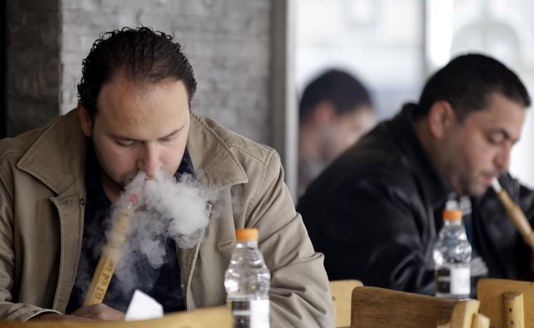 شبان يدخنون الأرجيلة في احد مقاهي عمّان